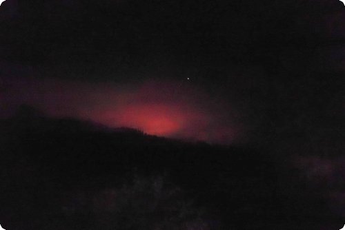 Ghostly: The sky over the mountains glows and blazes